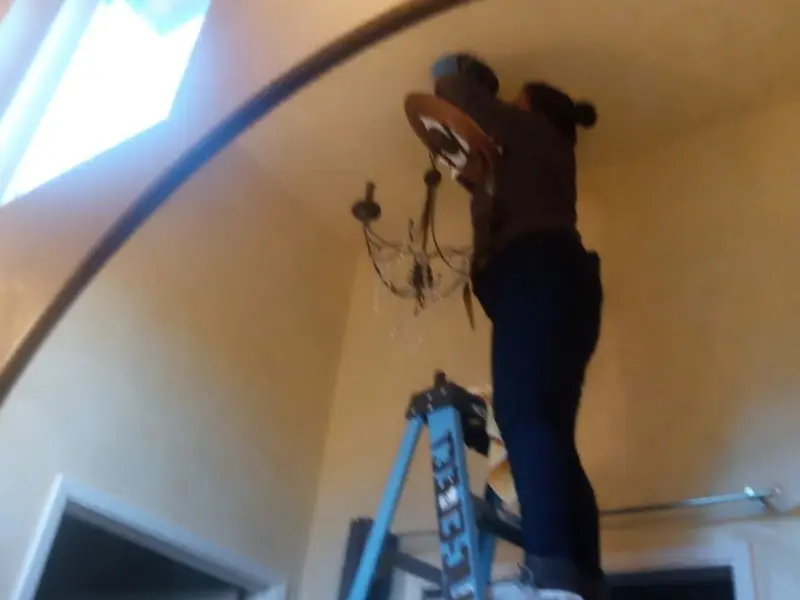 Electrician installing a chandelier in a Malta residence